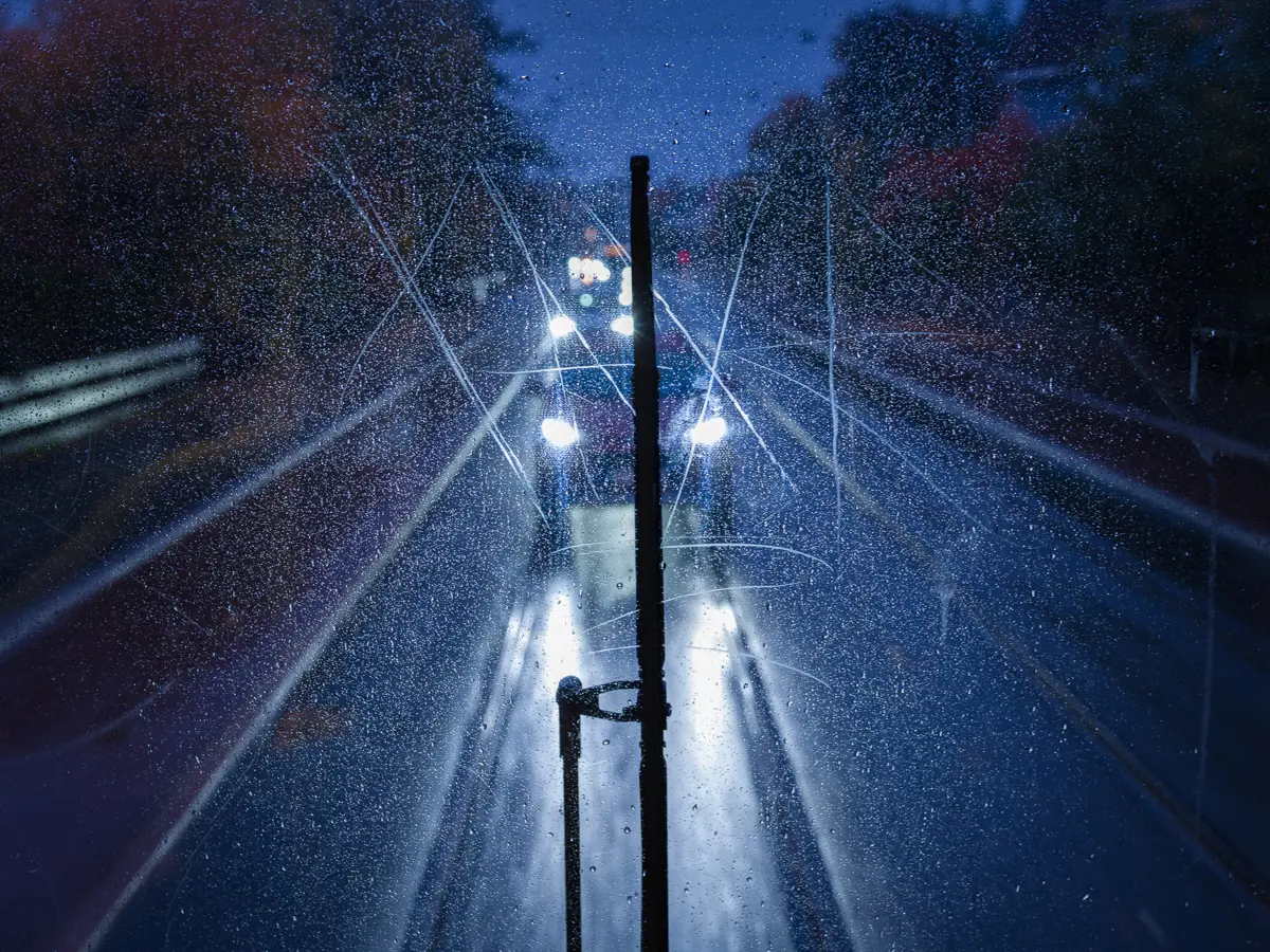 View of traffic following the tram on a rainy night, seen through the large, panoramic back window of SL79.