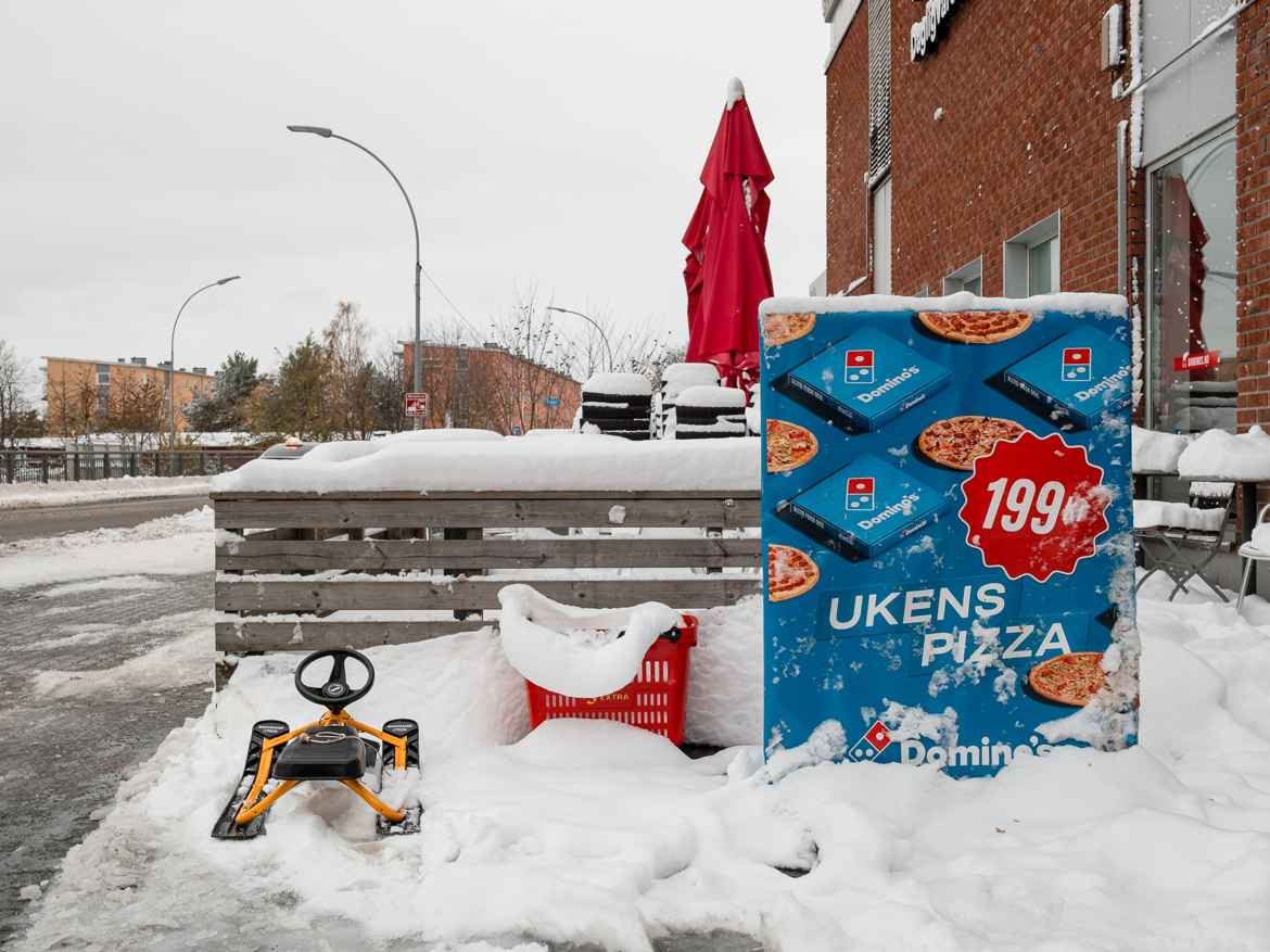 Snow sled parked outside shopping mall.