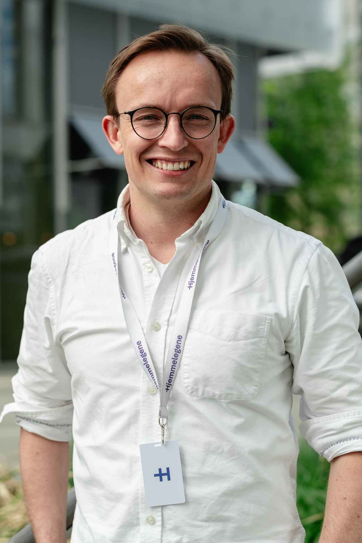 Man wearing white posing for company portrait