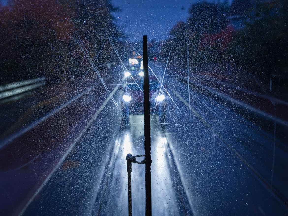 View of traffic following the tram on a rainy night, seen through the large, panoramic back window of SL79.